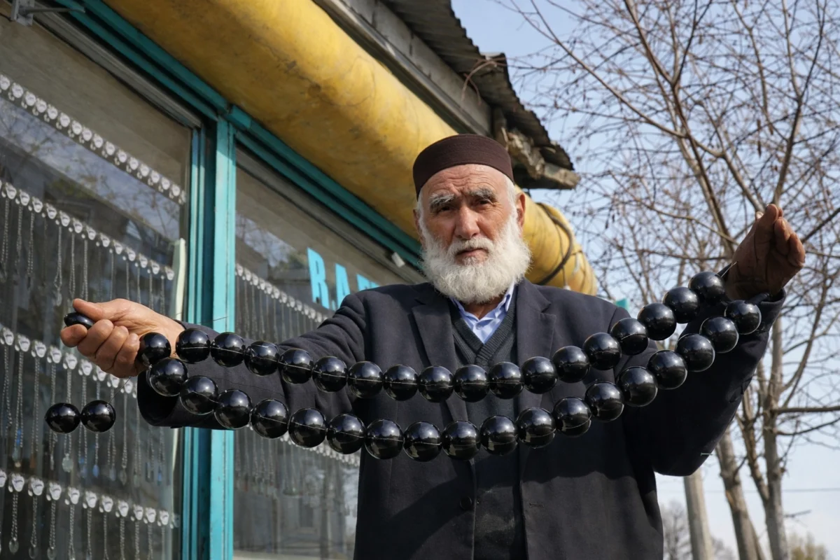 Erzurum Oltu Taşı Ustası – Gelenekten Geleceğe Tesbih Sanatı Erzurum’da oltu taşı ustası büyük boy tesbih tutarken, el işçiliği geleneksel üretim